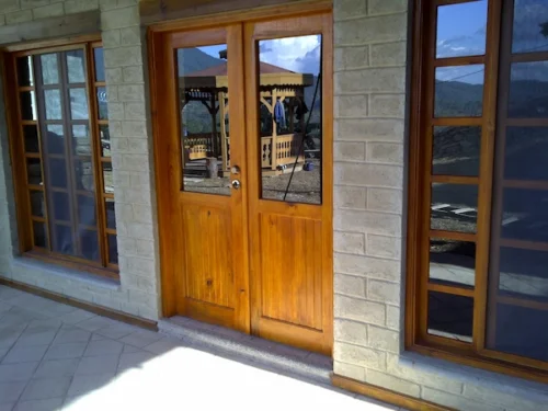 Carpintería de madera natural en puertas y ventanas de una vivienda ecológica de Ecomobilia